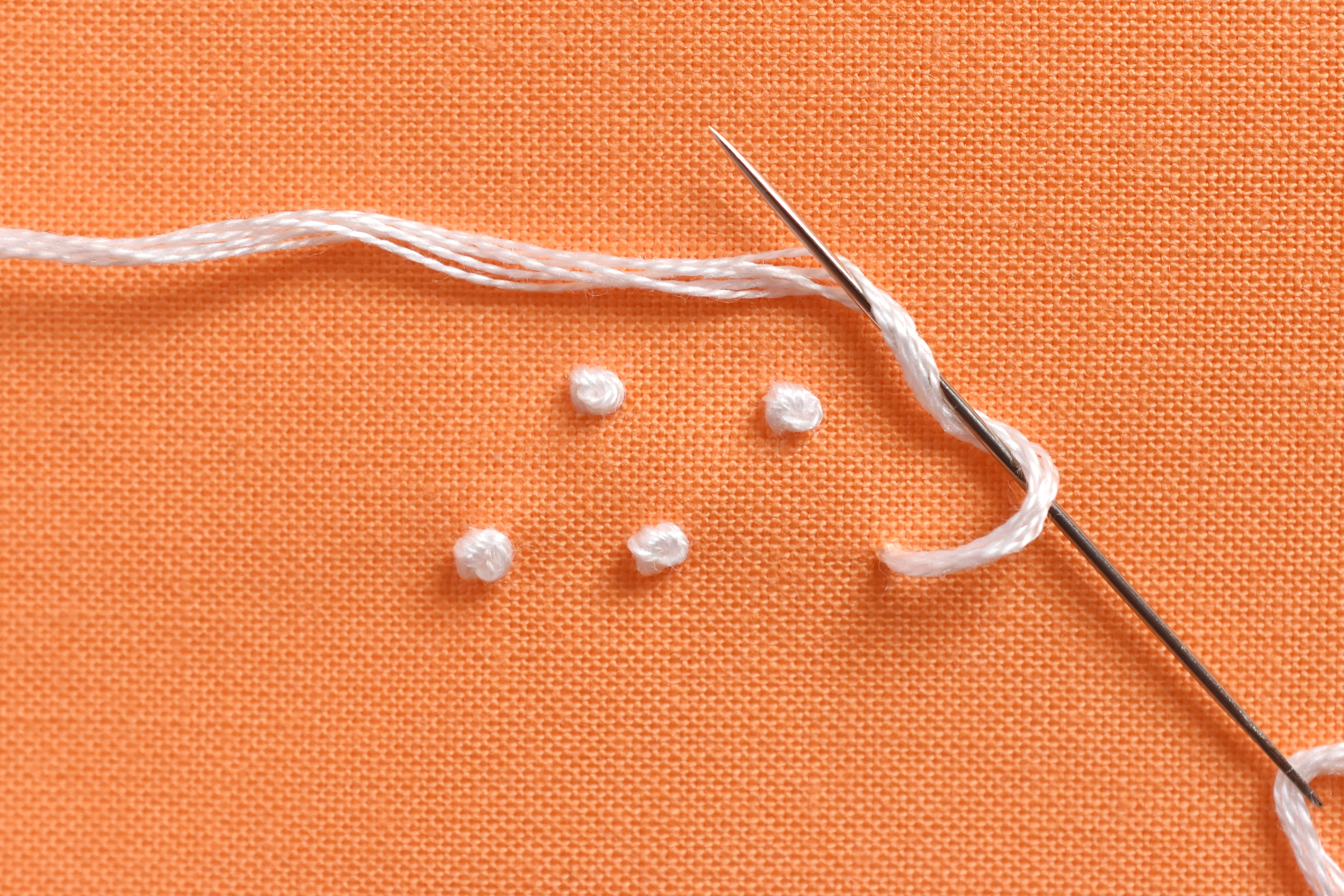 Wrap thread around needle to create the knots