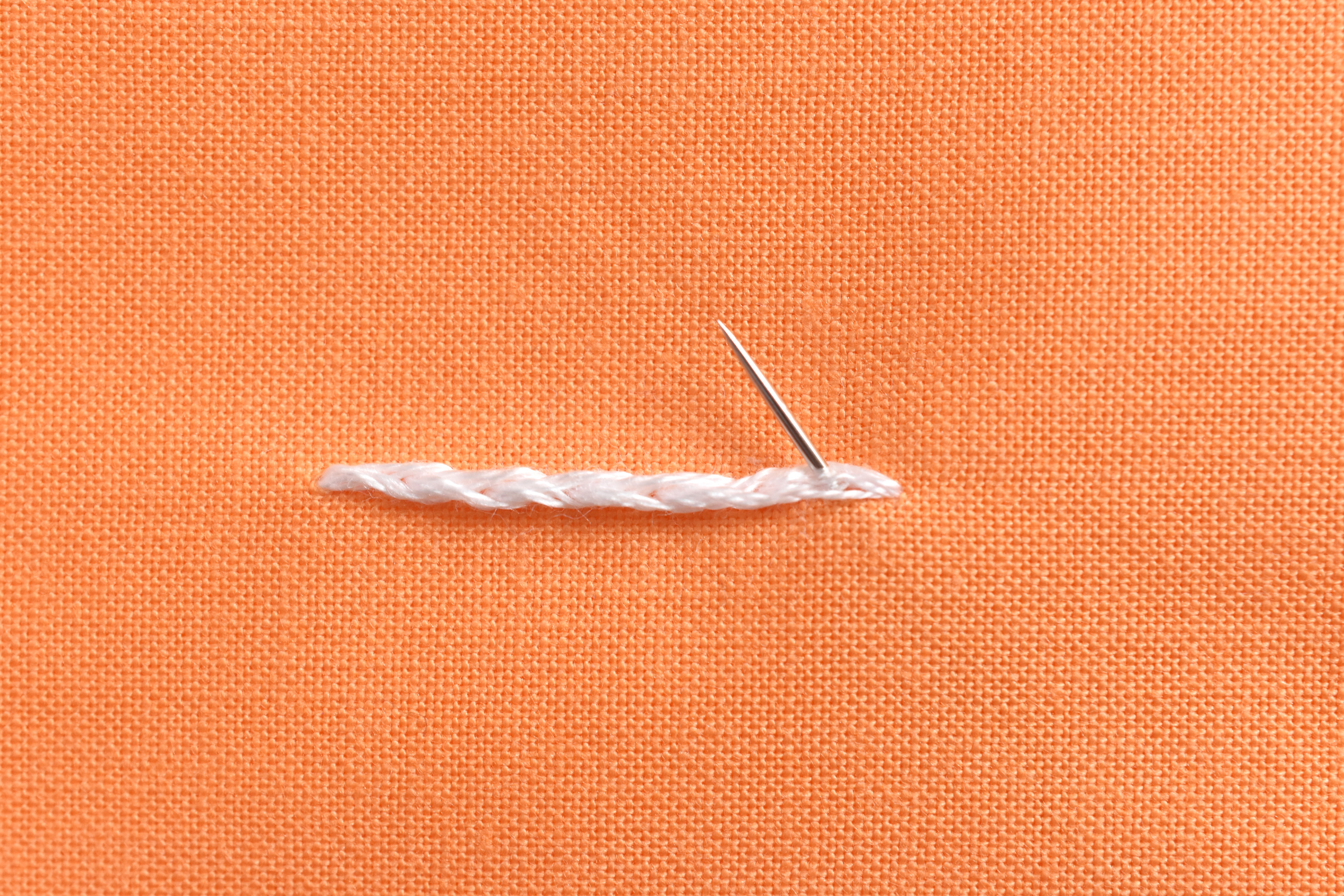 making a split stitch - going up through fabric and middle of the stitches