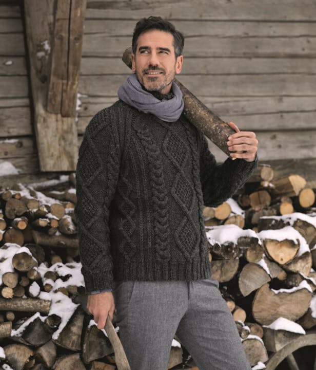 Man wearing a dark green cable knit sweater