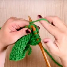 bring yarn around right needle to knit
