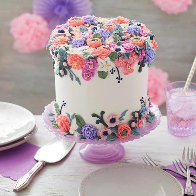 White cake frosted with multicoloured flowers