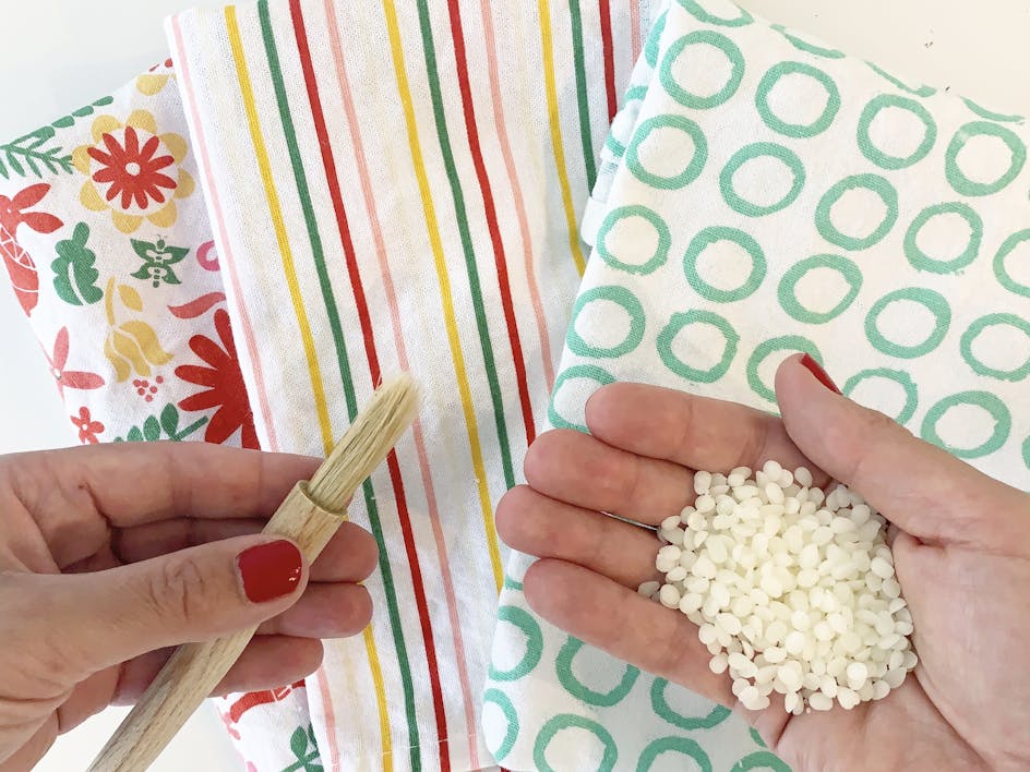 what you need to make your own beeswax food wraps - fabric, paintbrush and beeswax pellets