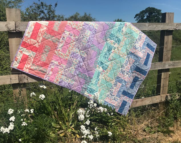 finished baby quilt, on fence