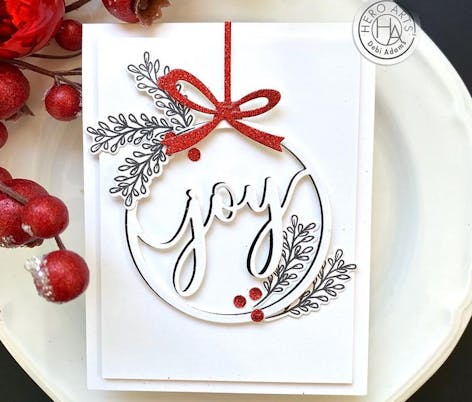 die cut bauble card design with joy cut out in the centre