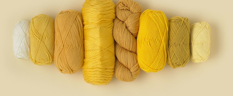 Different weights and fibres of yellow yarn