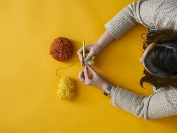 Woman crocheting with two balls of yarn