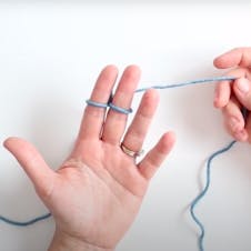 Move the working yarn tail to the back of your hand