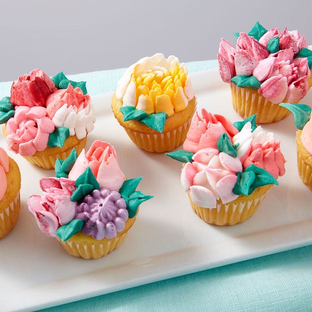 Cupcakes decorated with multicolored piped flowers